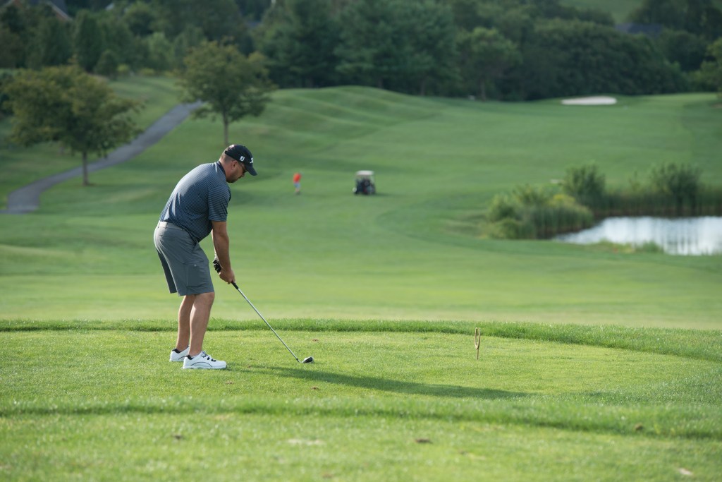 golfer teeing off